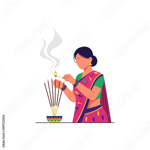 Woman in traditional attire lights incense sticks with a match, smoke rising, in a decorative bowl.