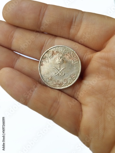 Hand holding a Saudi Arabia coin