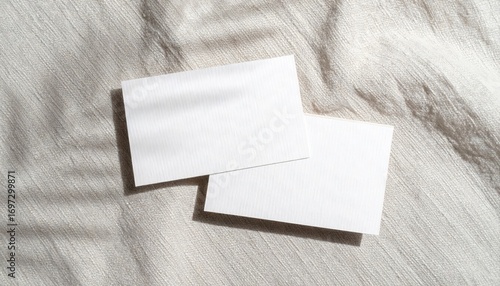 Two Blank White Business Cards Mockup on Textured Bone Linen Surface with Crisp Sunlight and Shadows