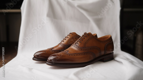 Classic brown leather brogue shoes, a timeless footwear choice for the discerning gentleman, on white fabric