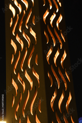 Decorative metal lantern with flame pattern glowing at night