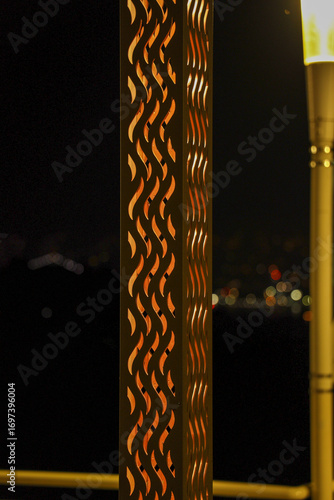 Decorative metal lantern with flame pattern glowing at night