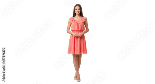 A young woman with long brown hair stands in a coralcolored, sleeveless dress with ruffles around the neckline and a cinched waist, isolated on a transparent background