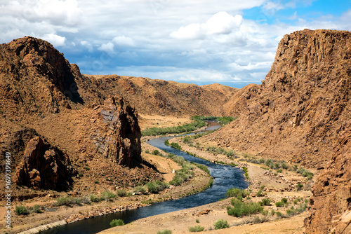 A stunning view of Khushuut Valley in Khovd Province, western Mongolia. This remote valley stretches toward the majestic snow-capped Sutai Mountain, offering breathtaking natural beauty, pristine wild