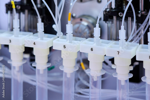 Automated liquid handling robot processing test samples in modern biopharma laboratory, close-up.