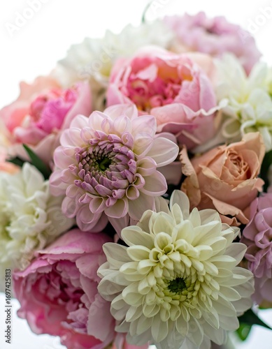 Close-up view of a beautiful bouquet featuring a variety of pastel-toned flowers, including pinks, peaches, and creams.  The arrangement showcases the delicate details and textures of each bloom.