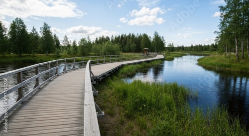 Wallpaper Mural Wooden boardwalk curves across river into green trees under a cloudy sky Torontodigital.ca