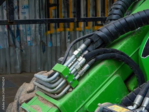 A close up photograph of the hydraulic hose connections on a piece of heavy construction machinery showcasing the complexity and power of the industrial equipment