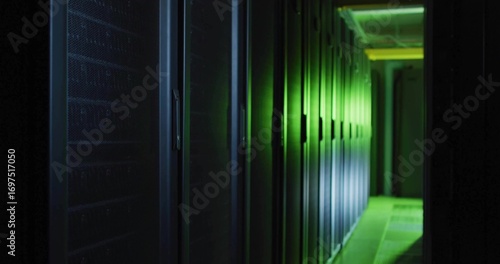 Glowing row of server racks lining data center corridor, with green LED lights and cable trays