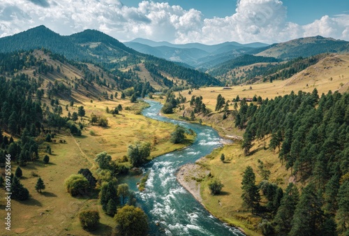A winding river snakes through a valley, framed by lush forests and rolling hills under a partly cloudy sky. Peaceful and serene
