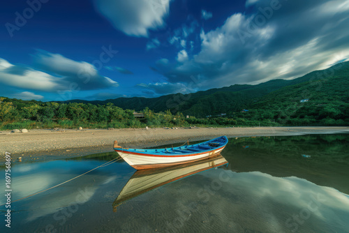 A boat resting on the shore of a calm lake with mountains and a cloudy sky in the background scene view