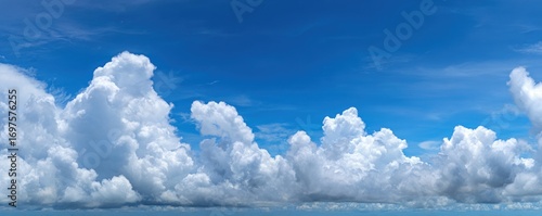 Panoramic view of a vivid blue sky filled with fluffy, white cumulonimbus clouds forming a picturesque horizon against the clear backdrop
