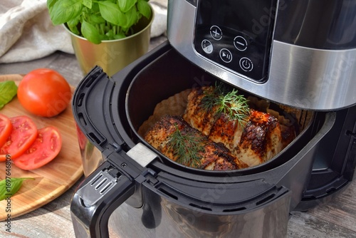 Meat cooked in a deep fryer. On the table are sliced ​​tomatoes and basil.