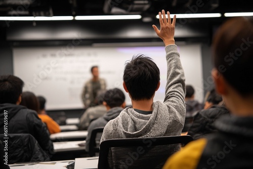 Student raises hand during a university lecture, seeking to participate actively