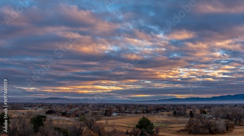 Dramatic sunset over a peaceful rural landscape with vibrant clouds.
