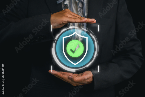 Businessman holding a digital insurance icon, representing security and assurance in modern technology.
