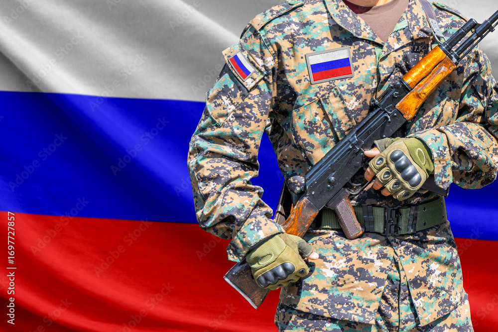 Fototapeta premium Russia flag with soldier in military uniform holding assault rifle in front of it