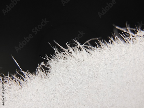 A detailed macro shot of a torn edge of white A4 paper. The image reveals the delicate, chaotic fibers and rough texture of the paper, creating an abstract and unique background for various projects.