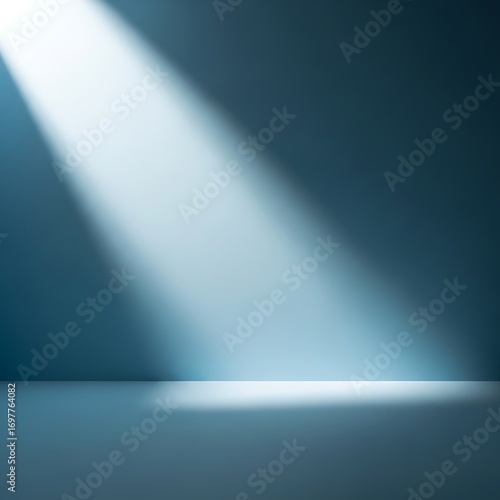 A single spotlight beam shines down from the top left onto a dark blue stage or floor, creating a dramatic and minimalist background.