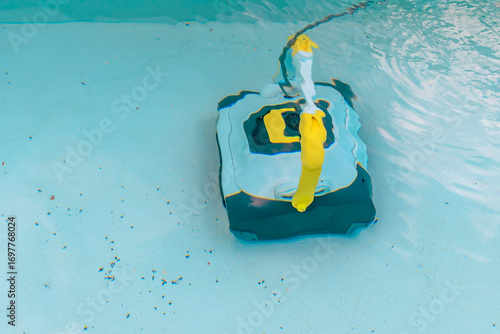 A robotic pool cleaner in action in the water to clean the dirty bottom of a swimming pool