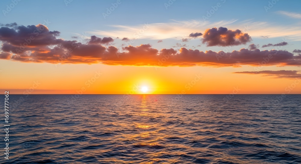 Obraz premium A beautiful sunset over the ocean with clouds and orange sky and sun reflection on water surface