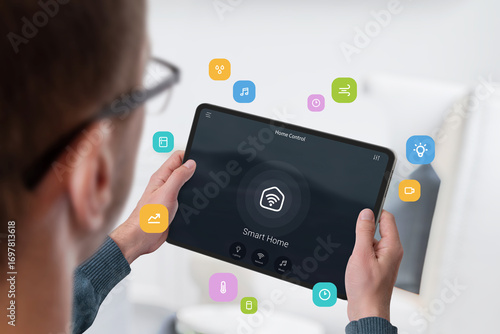 Man using tablet with smart home interface for device control