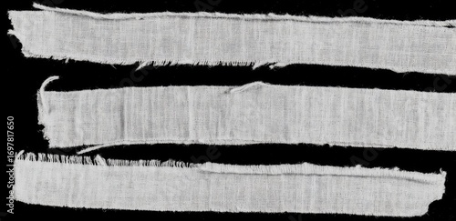 Three horizontal strips of frayed, light gray fabric against a black background