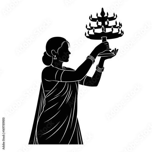 Silhouette of a woman holding a multi-tiered oil lamp, likely for a religious ceremony.