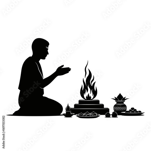 A silhouette of a man performing a traditional Hindu fire ceremony, a Puja with offerings.