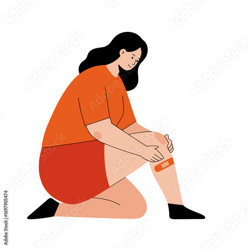 Woman applying medical plaster on her knee while kneeling  