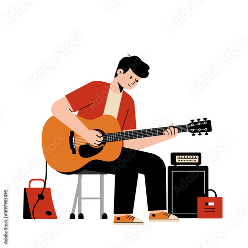 Young man playing guitar while sitting on stool in garage setting  