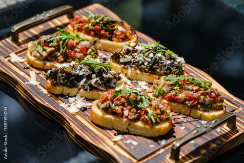 Tableau sur toile Delicious Assorted Bruschetta on Wooden Board with Fresh Toppings
