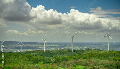 Panoramic view of wind farm with high wind turbines generating electricity. Sustainable energy, renewable power, and eco-friendly landscape with clear sky and copy space for clean energy concept.