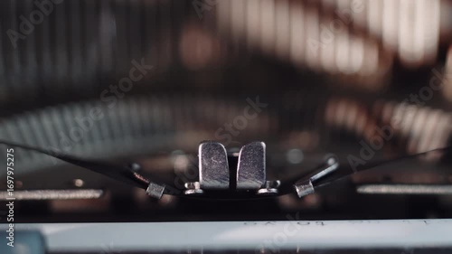 Close up typewriter. Type bars extreme close up print on paper. Cinematic shot of hammers typing letters on vintage typewriter.