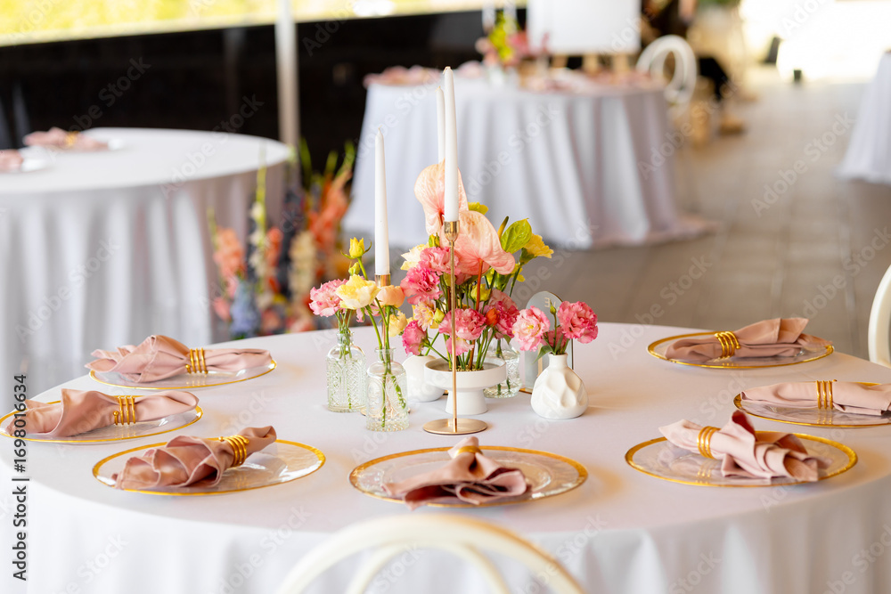 Fototapeta premium Table decor in a restaurant with beautiful vases of pink anthurium flowers, roses and carnations. Celebration, wedding