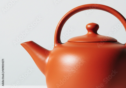 Wallpaper Mural Close-up of a terracotta-colored teapot with a rounded body, spout, lid, and arched handle against a plain white background. Torontodigital.ca