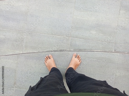 First Person View of A Man Standing Barefoot on a Floor