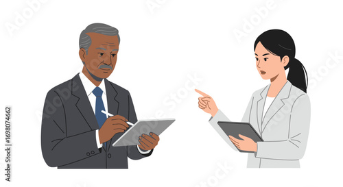 A man and woman in suits discuss holding tablets the woman points as the man takes notes
