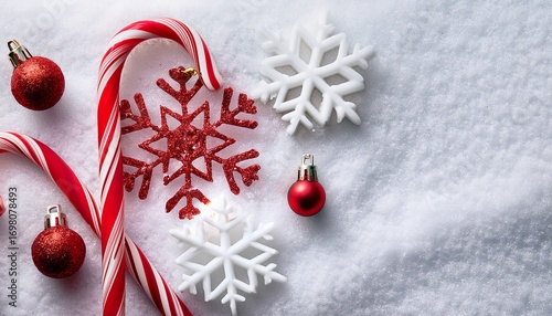 Top view of red and white candy canes and white glitter snowflake decorations on snow background. Generated image