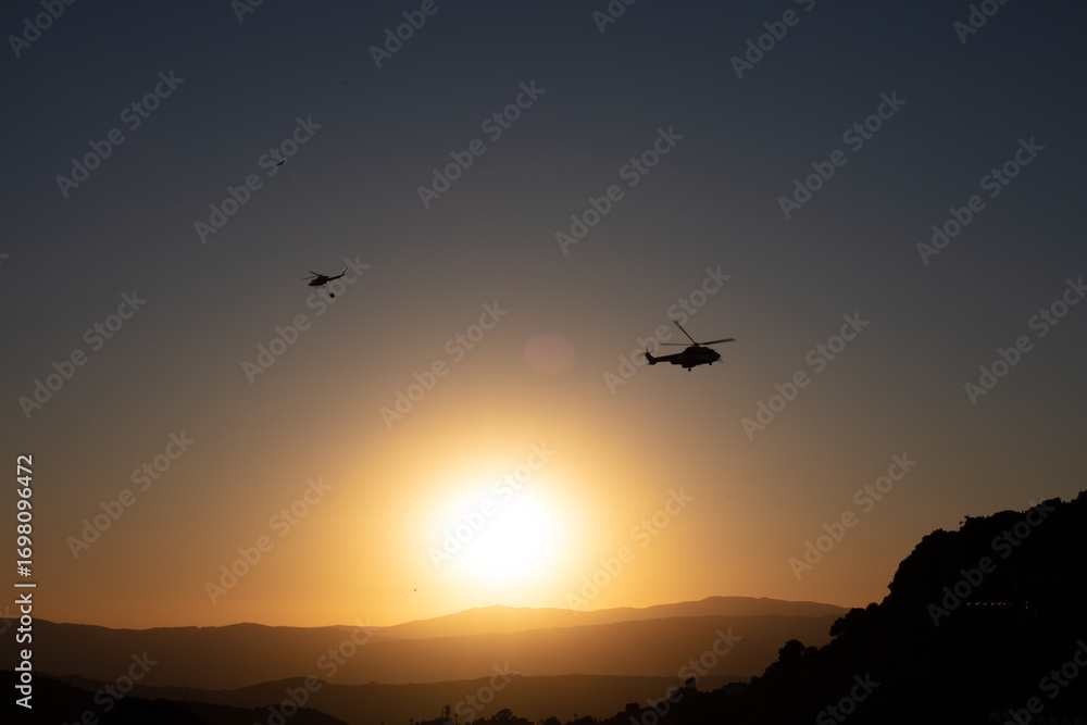Helicopters flying at sunset in Casares mountain landscape. Casares, Andalusia Spain. 5 September 2025. Helicopters flying at sunset in Casares mountain landscape. Casares, Andalusia Spain. 5 September 2025.