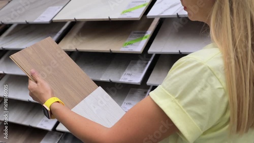 Hands holding ceramic tiles in hardware store comparing options for renovation