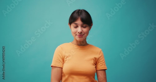 Hispanic woman looks from side to side on blue background