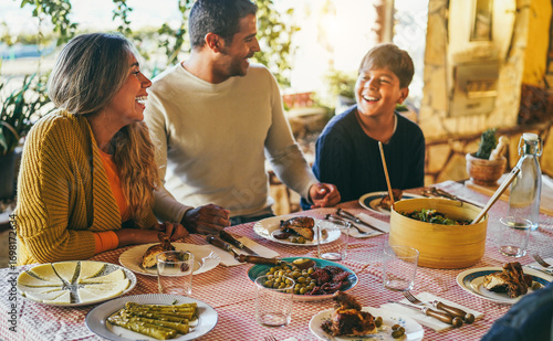 Happy latin family eating dinner together at home - Winter holidays and Christmas time concept - Main focus on mother face