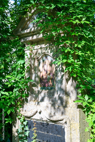 Zugewachsener Grabstein inmitten von grün  Alter Südfriedhof München