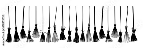A Collection of Black Silhouette Witch Brooms Hanging on a White Background