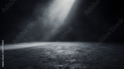 Moody spotlight illuminates dark asphalt floor
