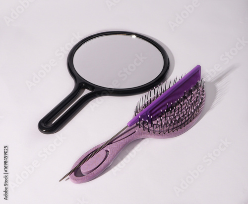 Violet combs with mirror on white background 