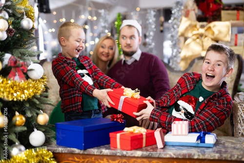 Smiling family celebrating Christmas and giving each other gifts