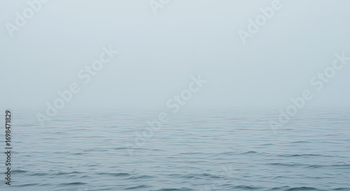 Calm ocean water under hazy sky
