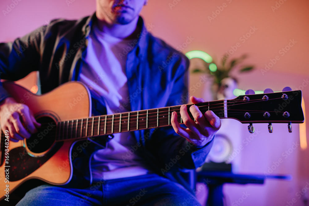 Obraz premium Musician composing music playing acoustic guitar at home